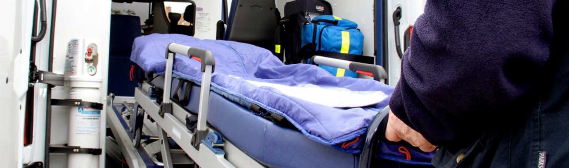 Ambulancier poussant un brancard dans une ambulance